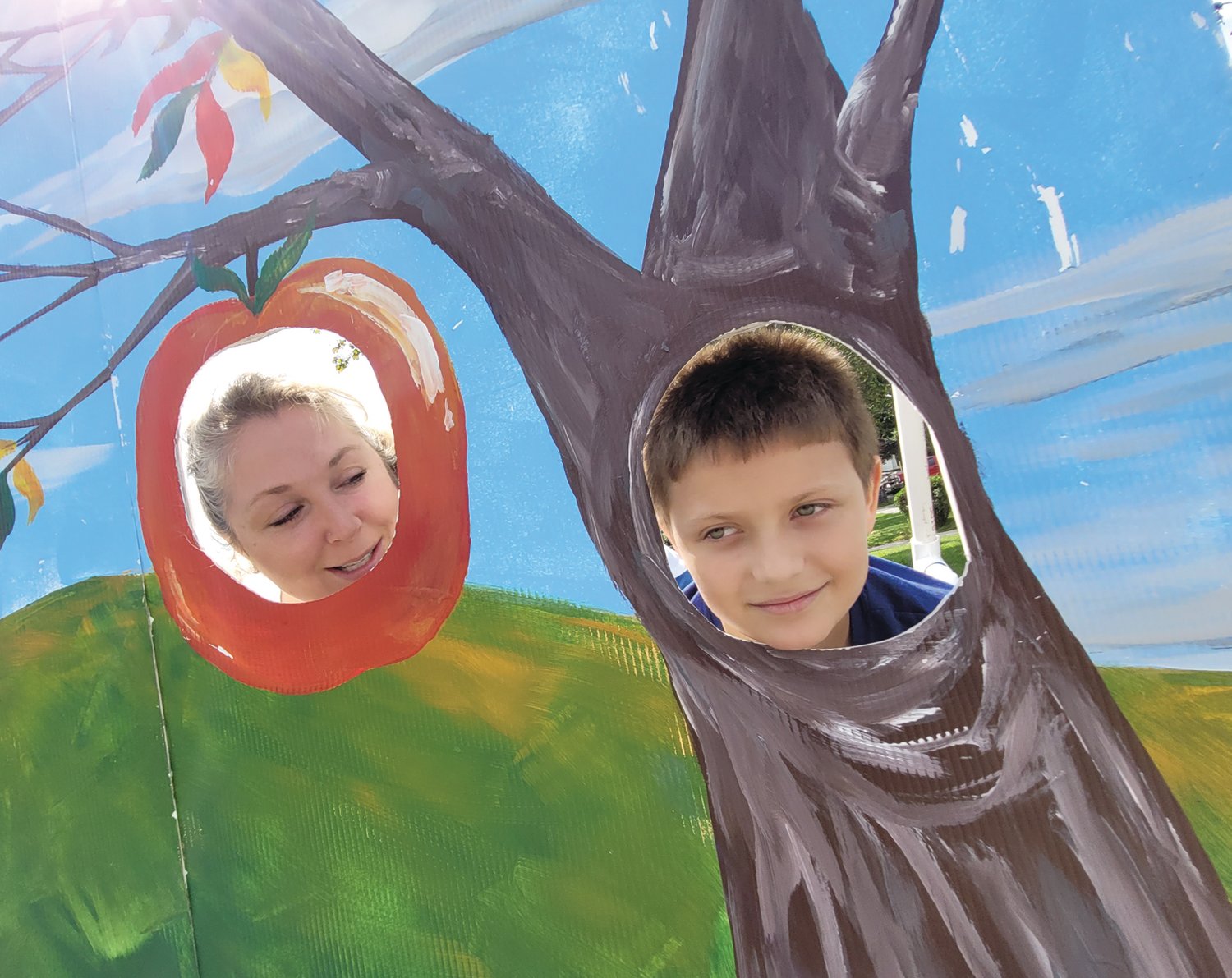 APPLE HEADS: Boston Wood posed with Katelin Fasciano, poking their heads through a cutout for photos at the Apple Festival last Saturday.